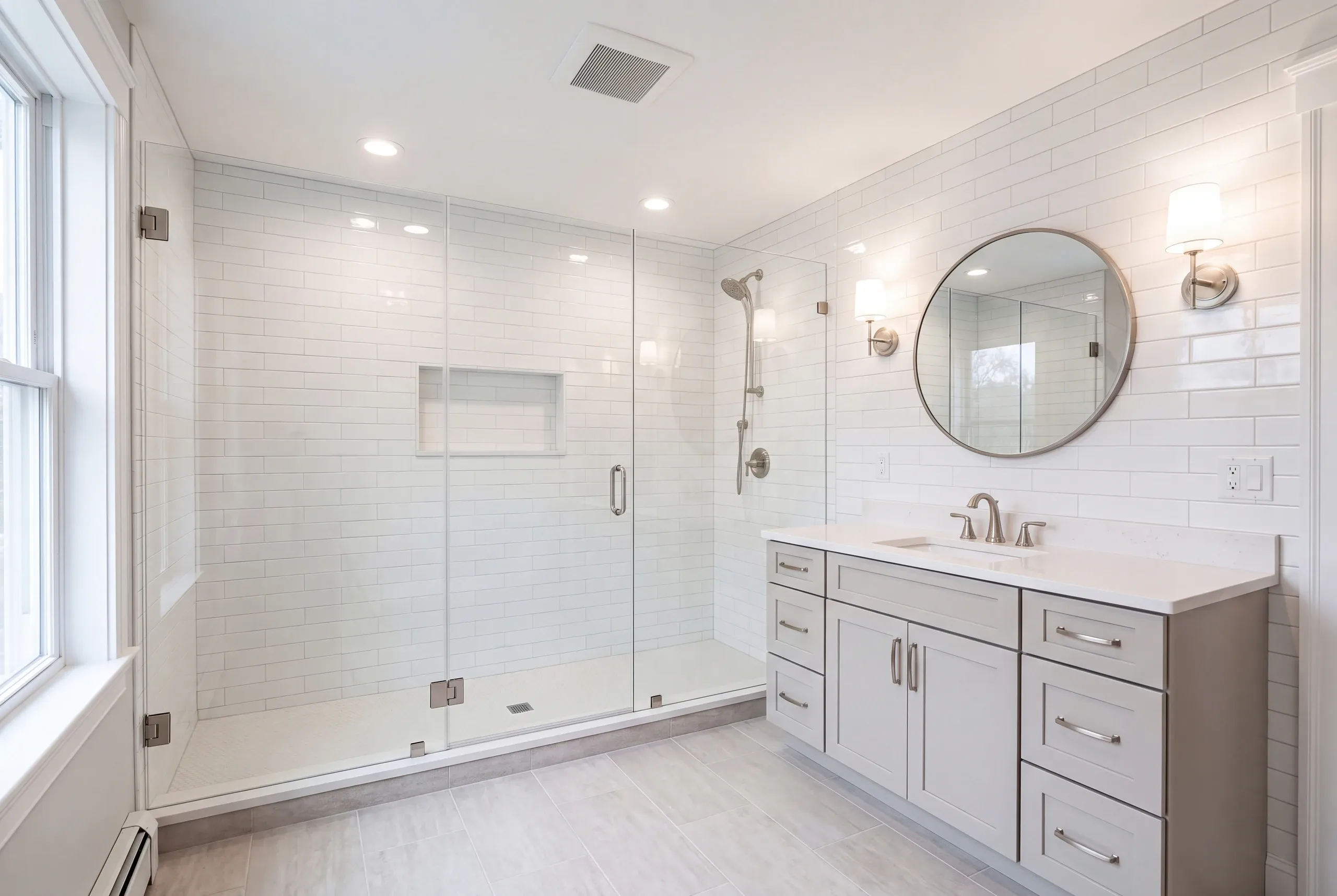 Bathroom remodeling in Augusta, ME: finished bathroom with a glass walk-in shower, white subway tile and a gray shaker vanity