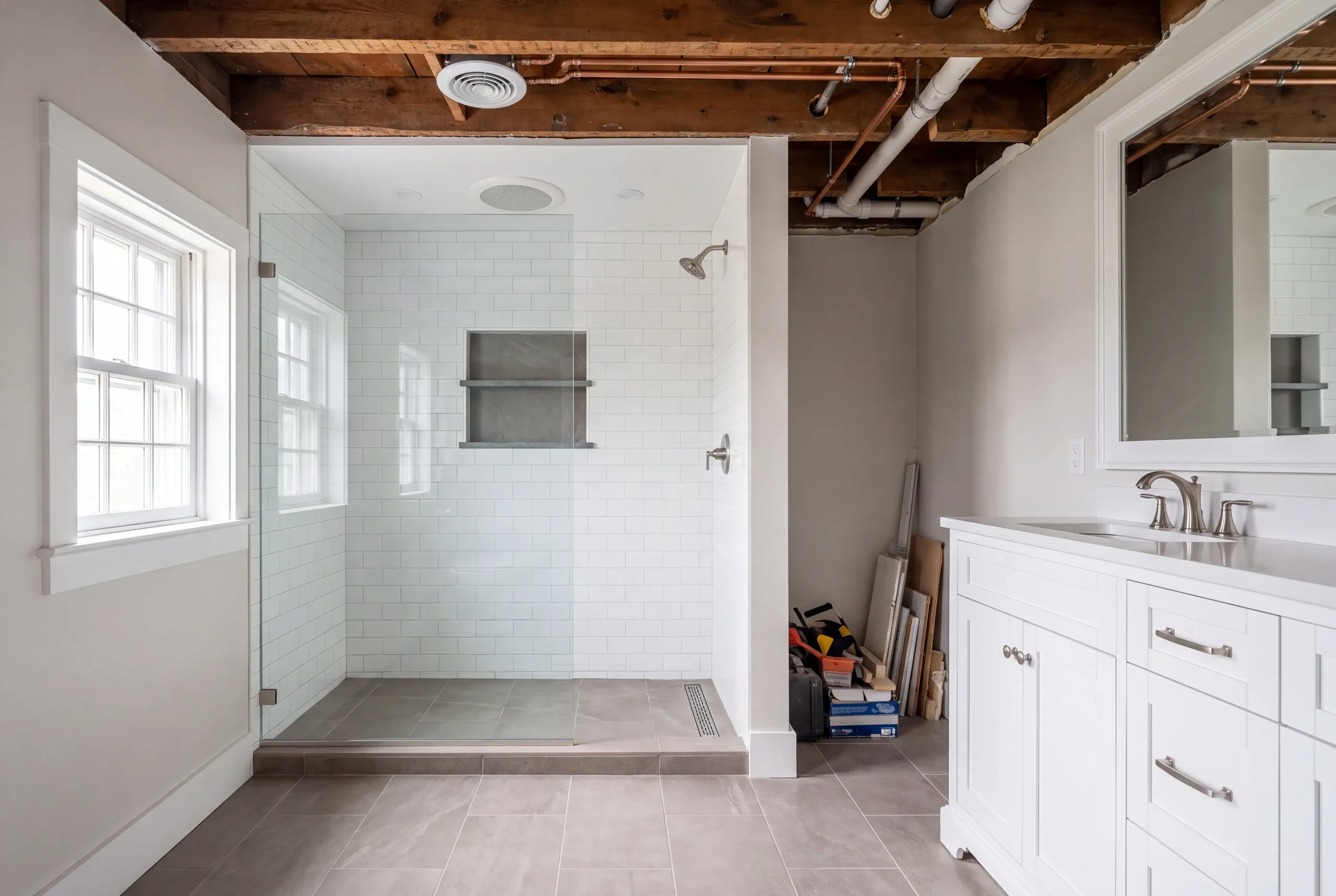 Bathroom remodeling contractor Bath Maine: bathroom with the ceiling open to old timber joists, copper supply and white PVC drain lines