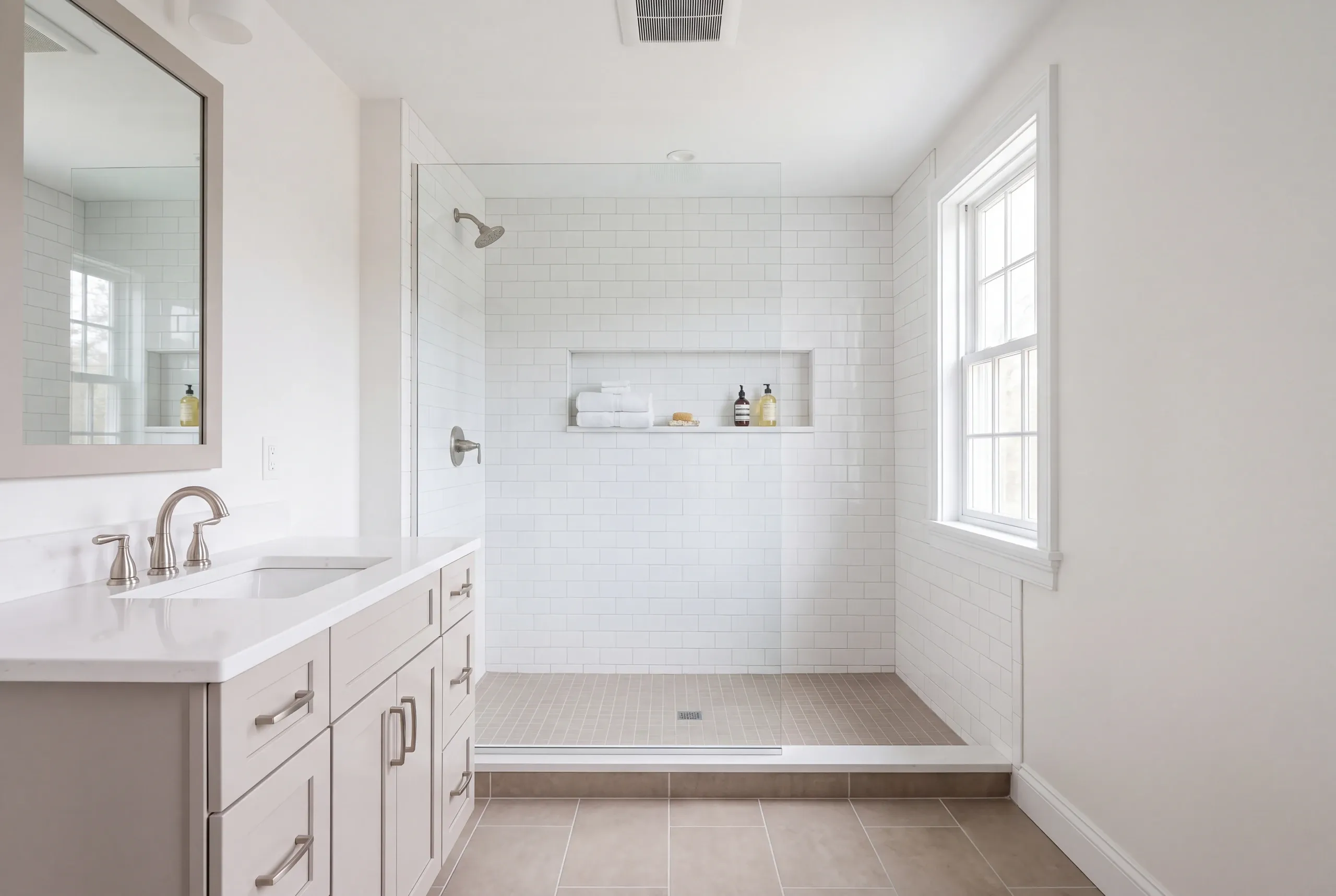 Bathroom remodeling in Bucksport, ME: walk-in shower with white subway tile, a long niche and linear drain beside a pale gray vanity