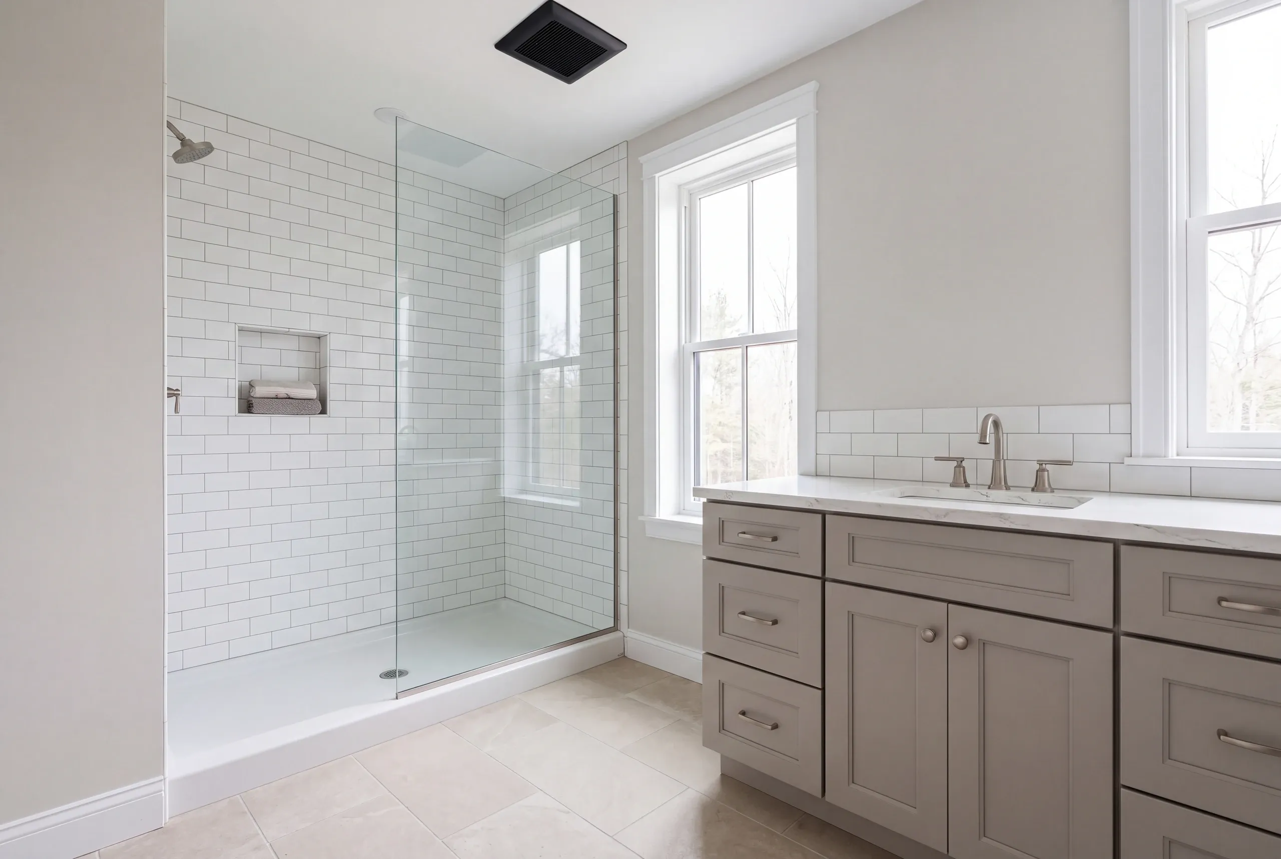 Bathroom renovation contractor Gardiner Maine: bathroom with a subway tile shower on a white base and a long gray shaker vanity