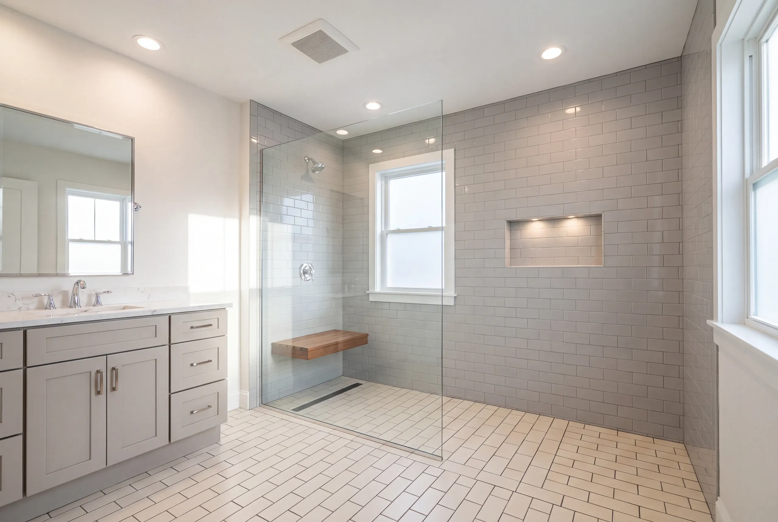 Bathroom renovation contractor Pittston Maine: curbless gray subway tile shower with a wood fold-down bench and linear drain