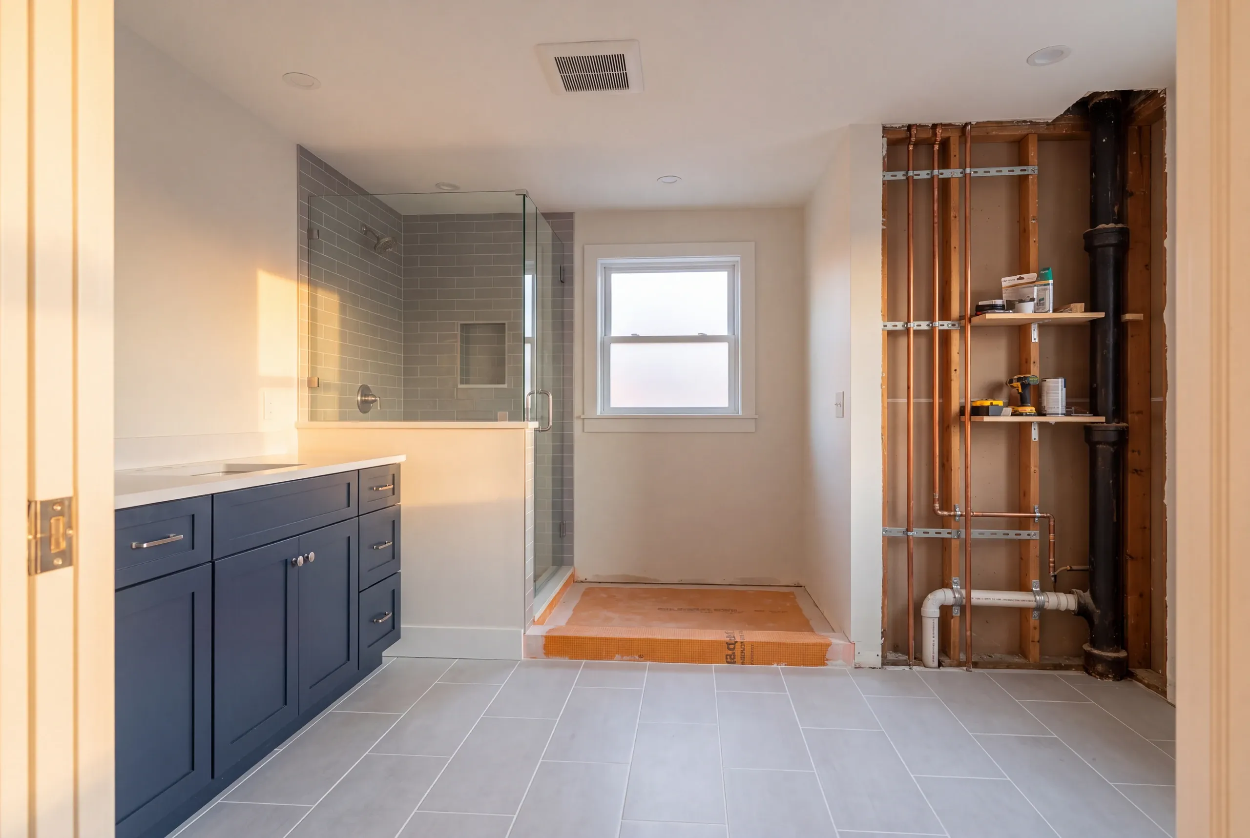 Bathroom remodeling contractor Searsmont Maine: bathroom remodel with an open stud wall showing a black drain stack and copper supply lines