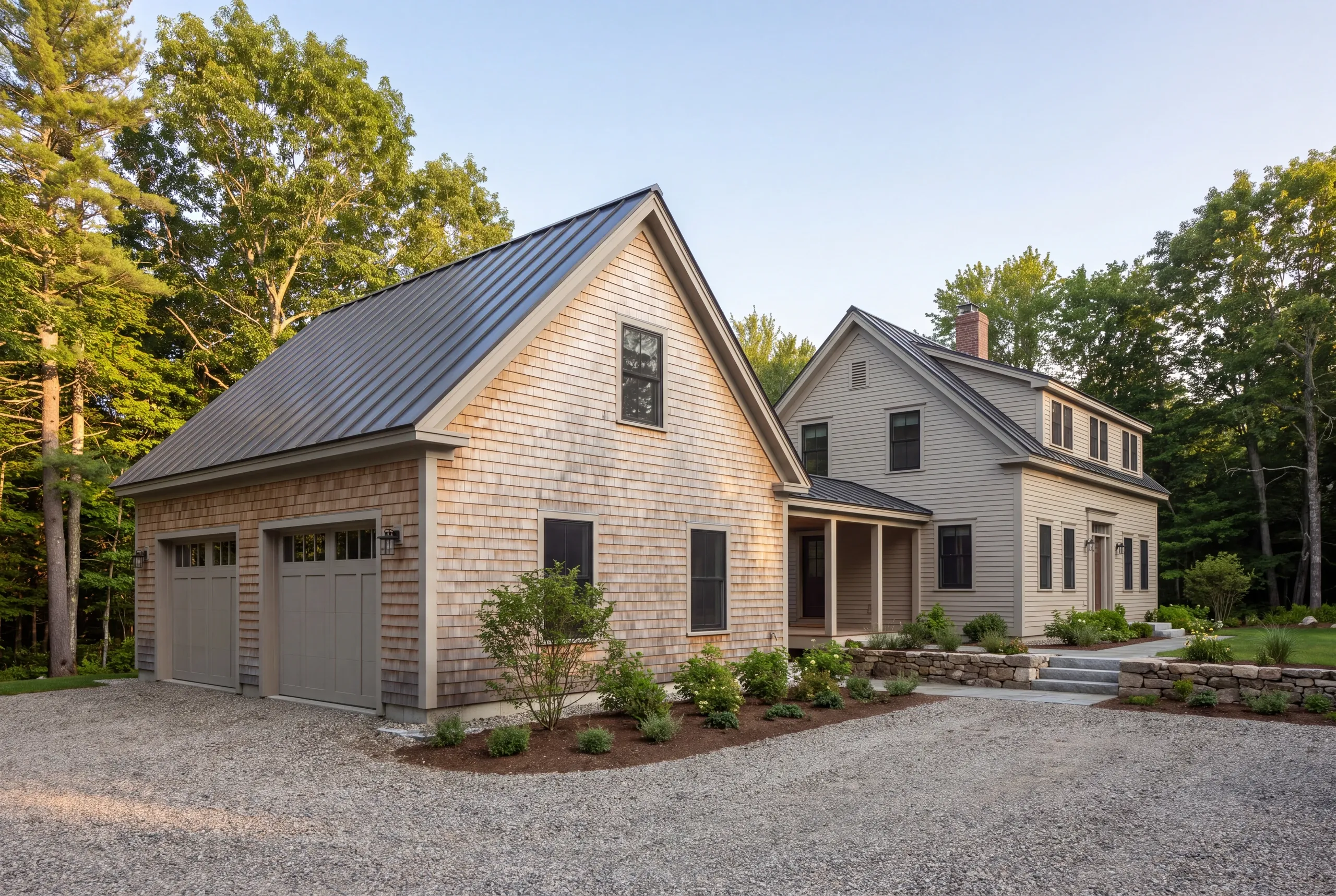 Cedar-shingled two-car garage with a standing seam roof joined to the house by a covered breezeway