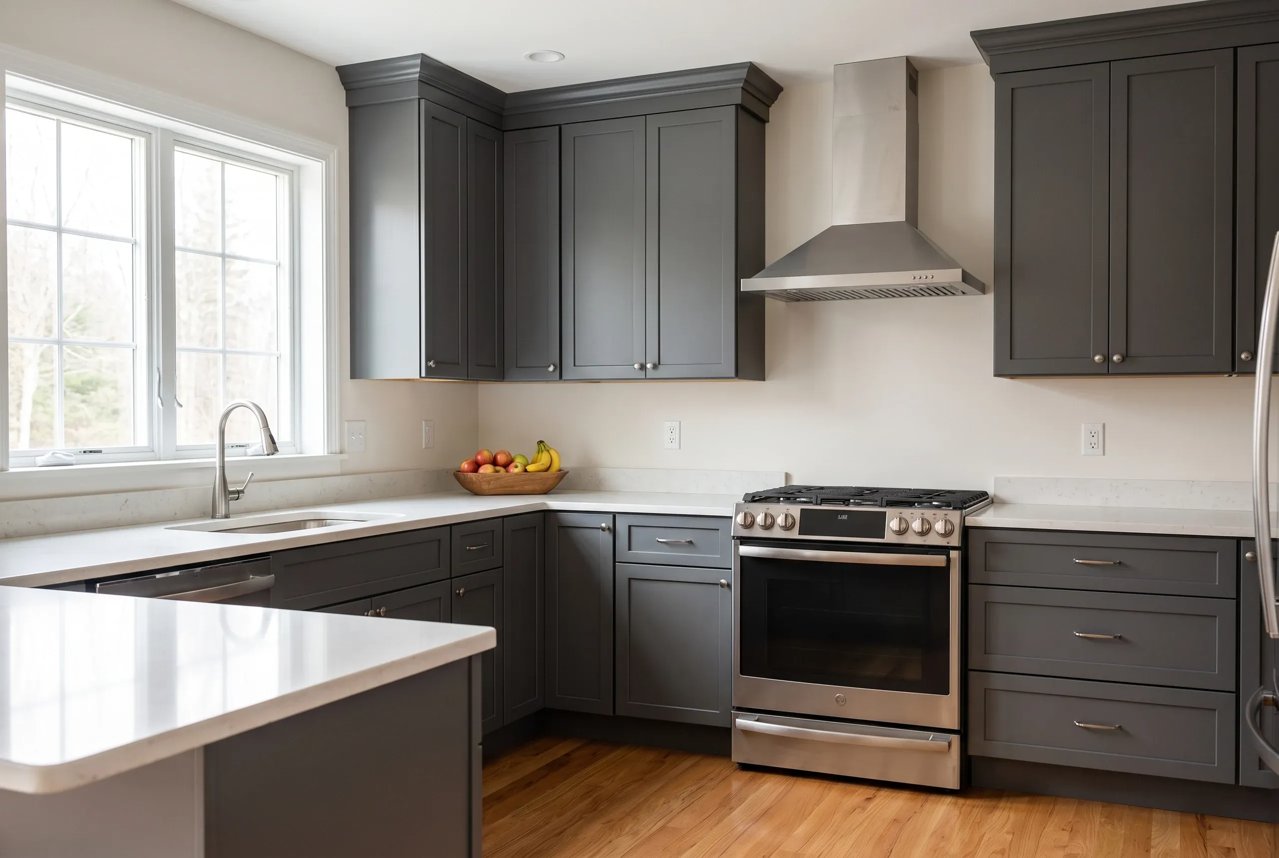 Kitchen renovation contractor Searsmont Maine: dark gray shaker kitchen with stainless chimney hood, slide-in range and a window on light oak floor.