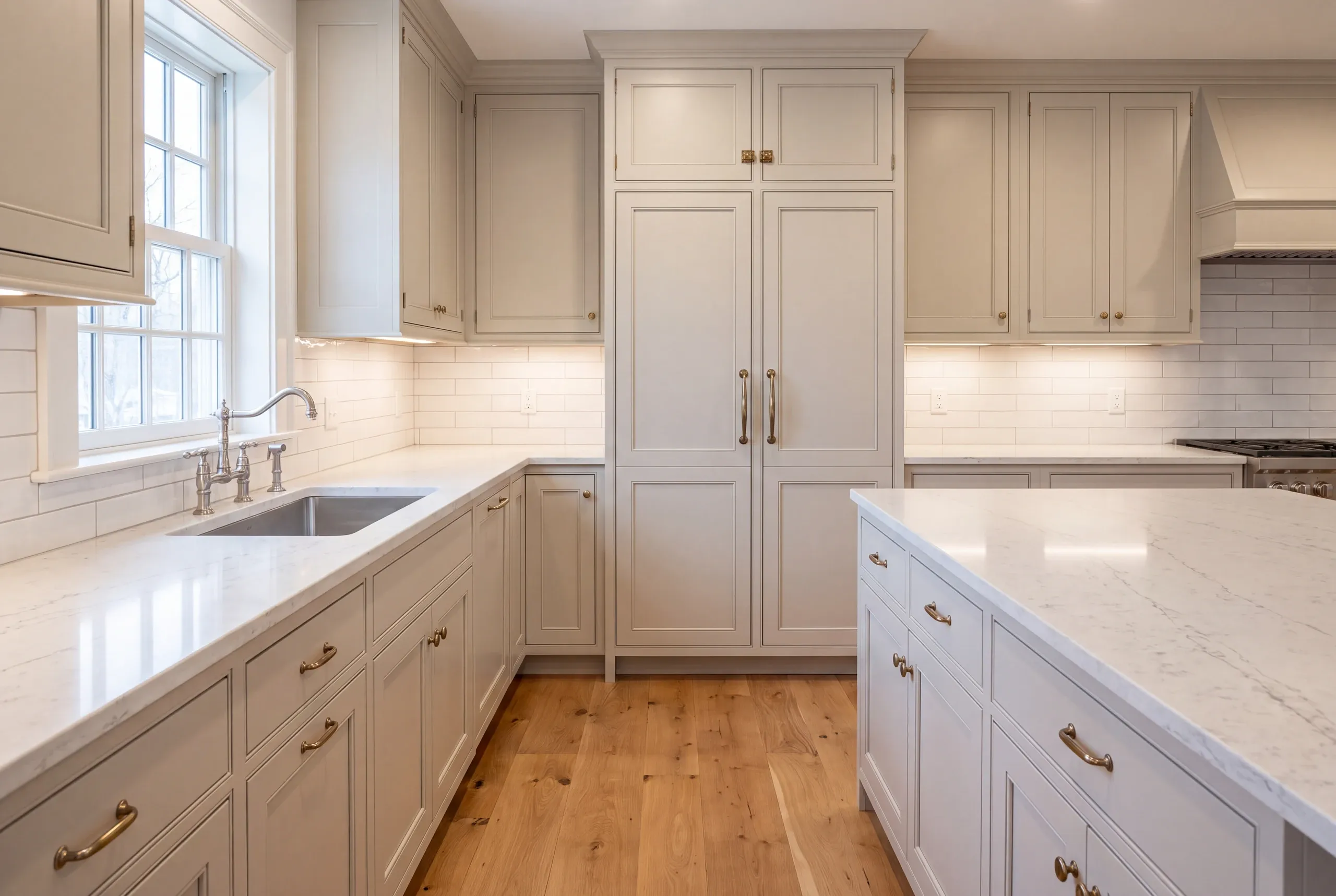 Kitchen remodeling contractor Thomaston Maine: tall greige inset pantry cabinet with brass latches between counter runs