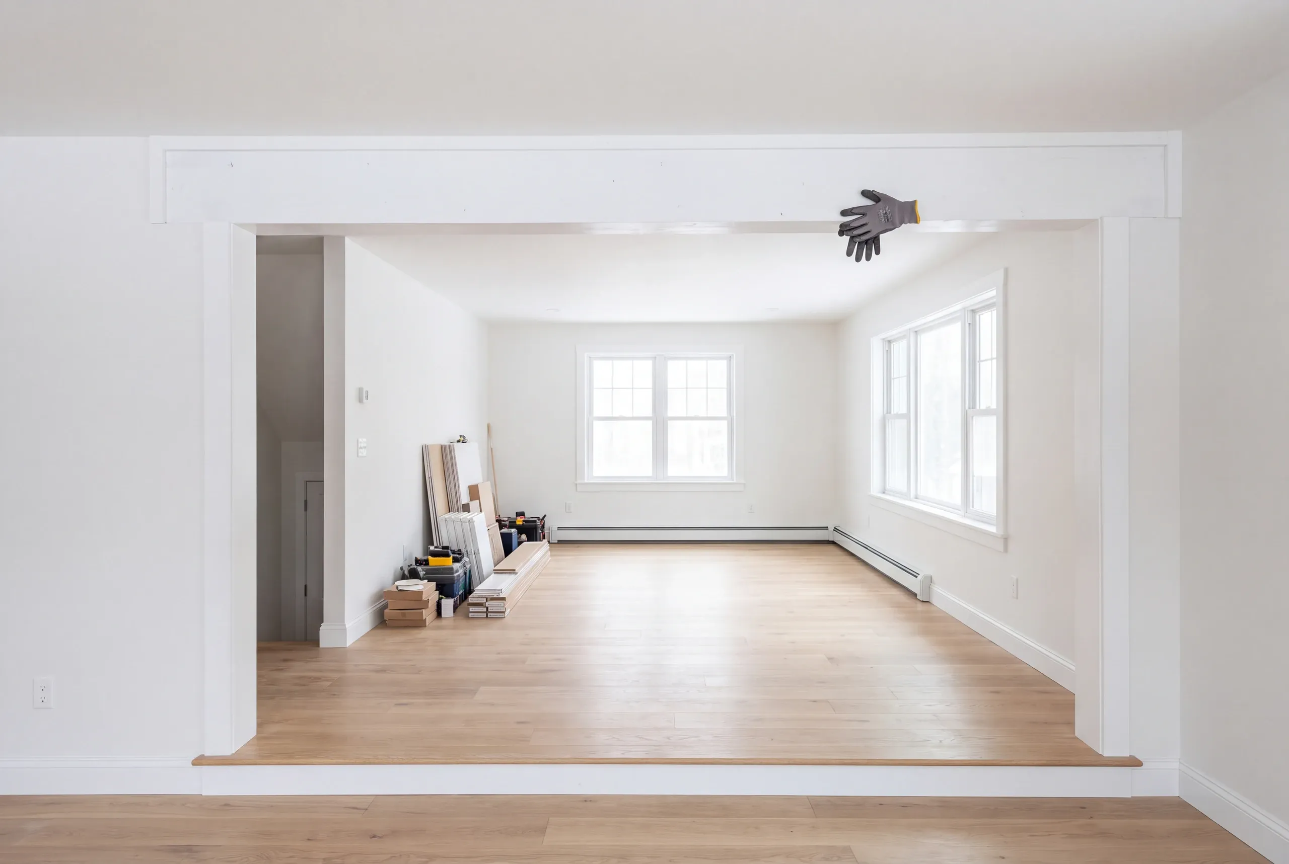 Home remodeling contractor Fairfield Maine: wide opening with a step up into a room with flooring, tools and trim stacked