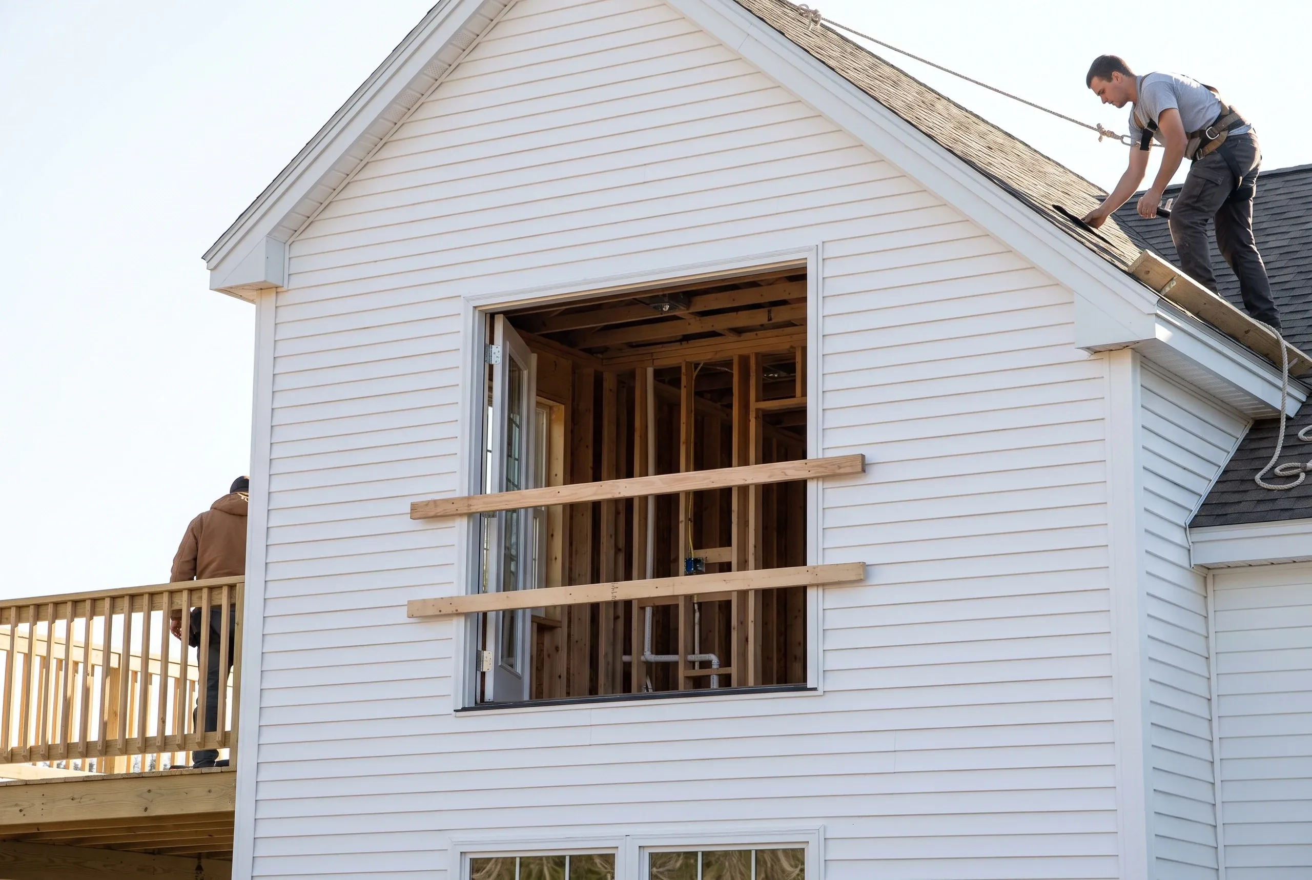 Remodeling company Rockport Maine: second-story wall opening guarded by temporary boards, with framed rooms and plumbing inside