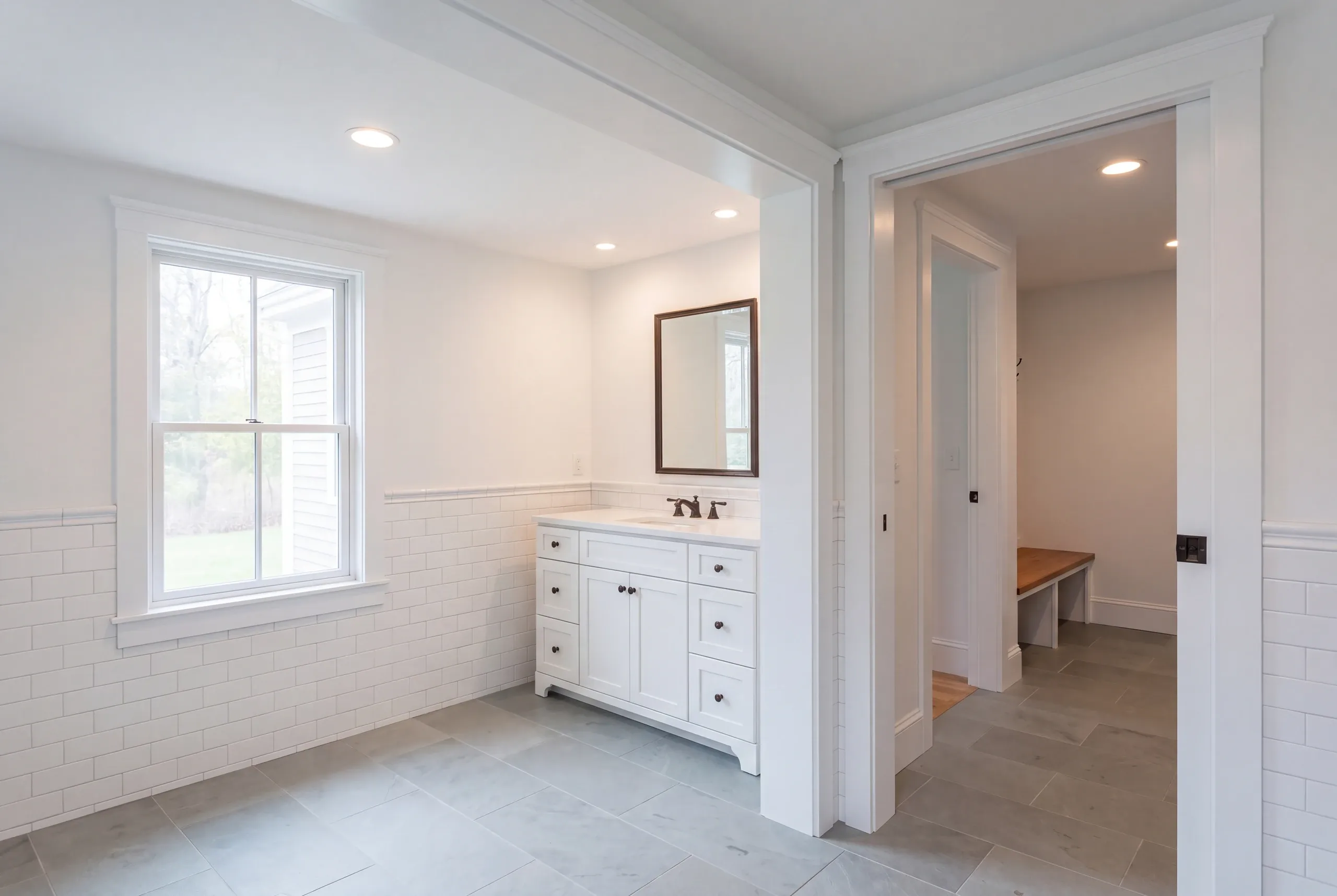 Home renovation contractor Rockport Maine: bathroom with a white vanity, subway tile wainscot and slate-look floor tile